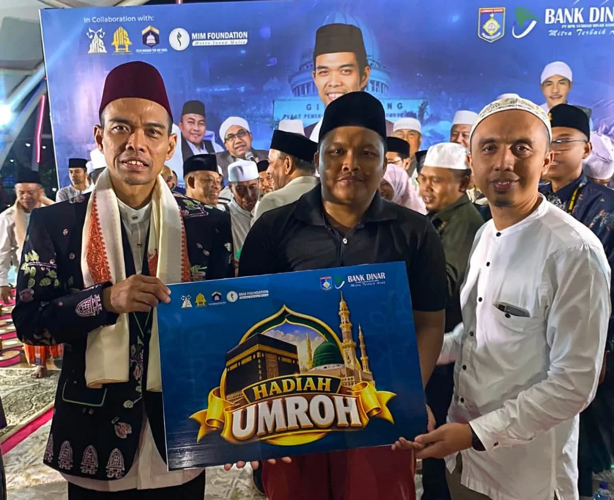 Foto:&nbsp;Direktur Kepatuhan Bank Dinar, Zaki Zamani (kanan) bersama&nbsp;Prof. KH Ustaz Abdul Somad (UAS) (kiri) menyerahkan hadiah umroh kepada jamaah.